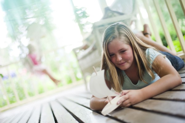 Young girl playing with toy boat. Photo : Tim Pannell
