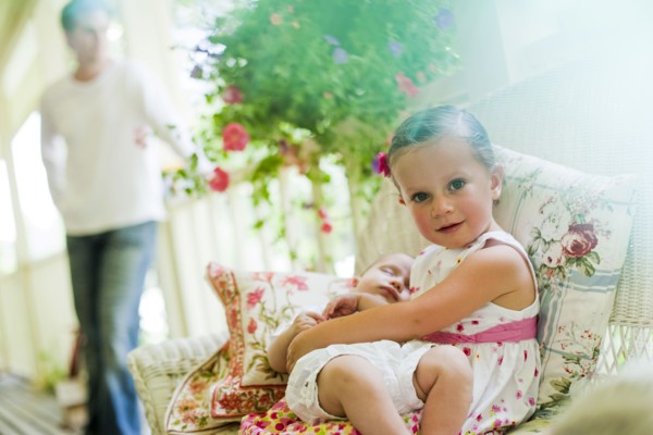 Young girl holding her baby sister. Photo. Tim Pannell