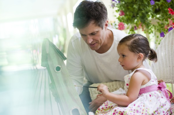 Father helping his daughter paint a birdhouse. Photo. Tim Pannell