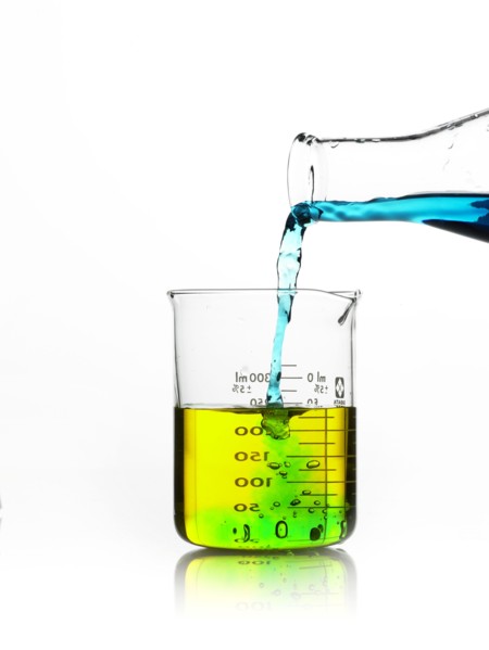 Blue liquid being poured into measuring cup. Photo. David Arky