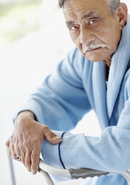 Elderly patient leaning on a walker. Photo. momentimages