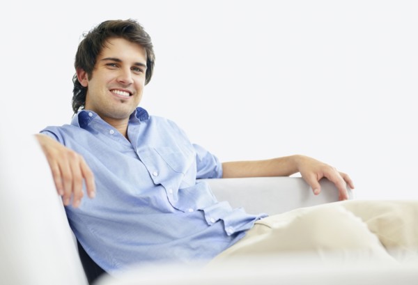 Handsome man relaxing on couch. Photo. momentimages