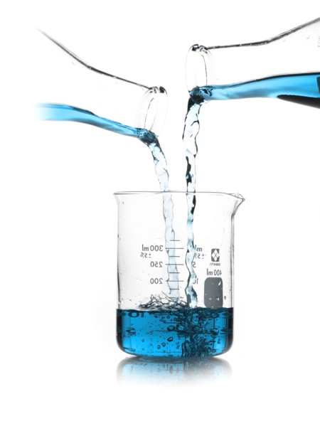 Blue liquid being poured into measuring cup. Photo. David Arky