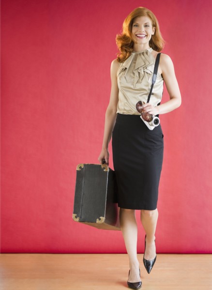 Attractive woman carrying a suitcase. Photo : Jamie Grill