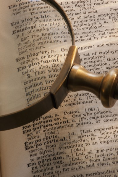 Magnifying glass over dictionary.