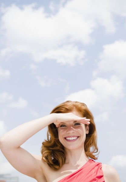 Beautiful woman shielding her eyes from the sun. Photo : Jamie Grill