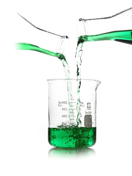 Green liquid being poured into measuring cup. Photo. David Arky
