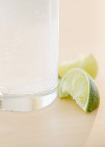Slices of lime beside glass of water. Photo : Jamie Grill