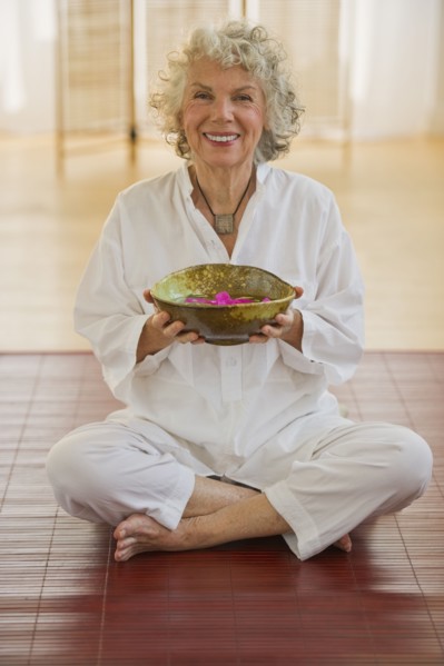 Woman holding bowl of flower petals. Photo. Daniel Grill