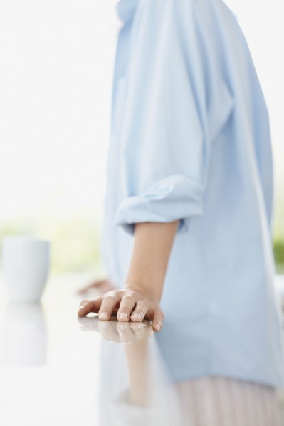 Woman leaning on kitchen counter. Photo : momentimages