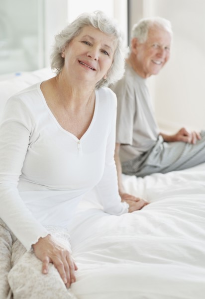 Relaxed senior couple sitting on bed. Photo. momentimages