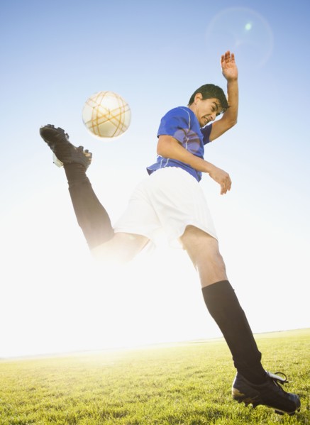 Soccer player jump kicking. Photo. Mike Kemp