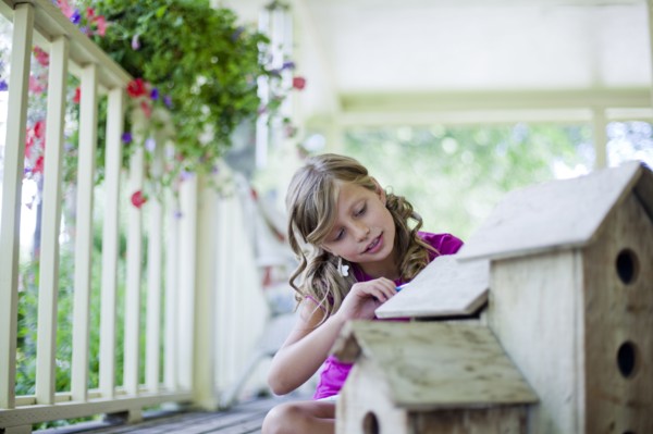Young girl painting a birdhouse. Photo. Tim Pannell