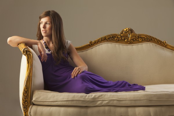 Elegant woman lounging on antique sofa. Photo : Mike Kemp