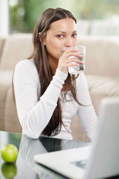 Woman drinking a glass of water. Photo : momentimages