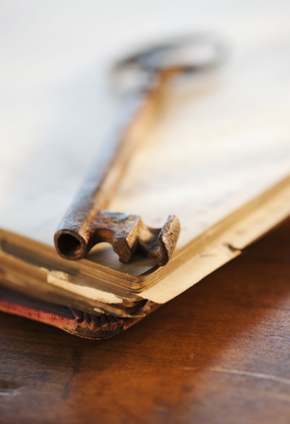 Antique key on top of book.