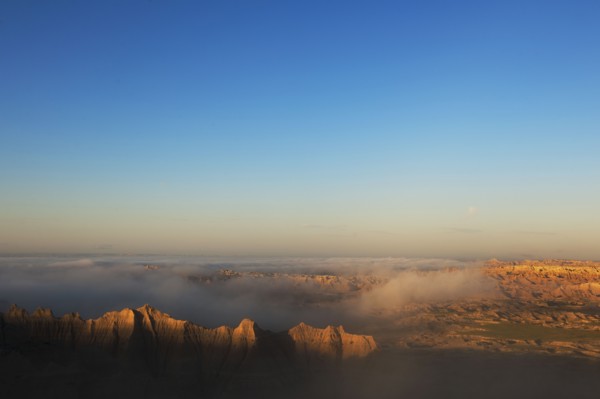 USA, South Dakota, Mountains in morning fog in Badlands National Park.