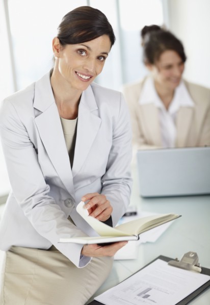 Two businesswomen working in office. Photo : Momentimages