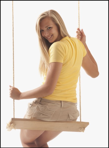 Portrait of young girl (16-17) on swing. Photo : Mike Kemp