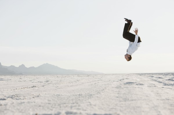Young man doing backflip in desert. Photo : FBP