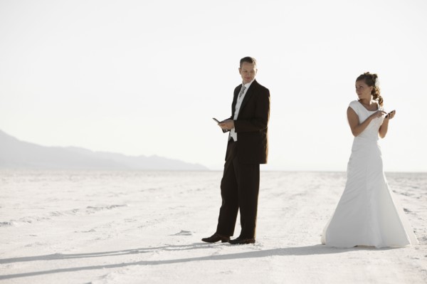 Bride and groom texting in desert. Photo : FBP