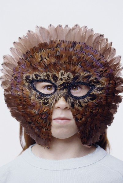 Child wearing a feather mask. Photo : Fisher Litwin