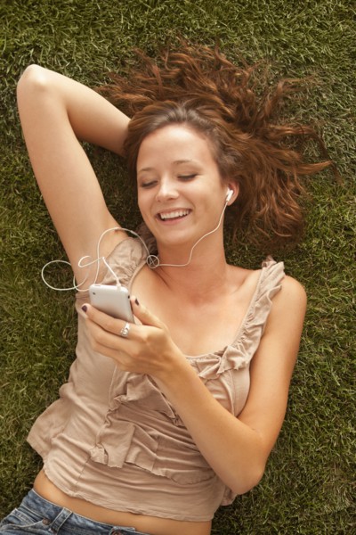 Young girl (16-17) lying on grass. Photo : Mike Kemp