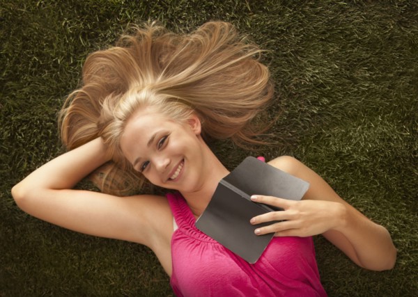 Young girl (16-17) lying on grass. Photo : Mike Kemp