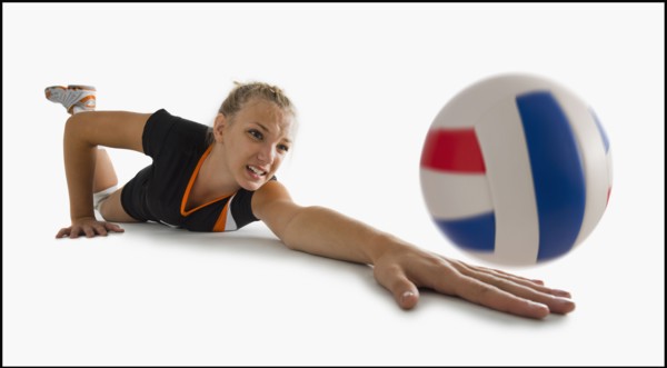 Young girl (16-17) playing volleyball. Photo : Mike Kemp