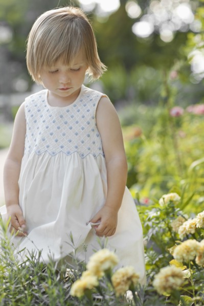 Girl (2-3) by flowers in garden. Photo : FBP