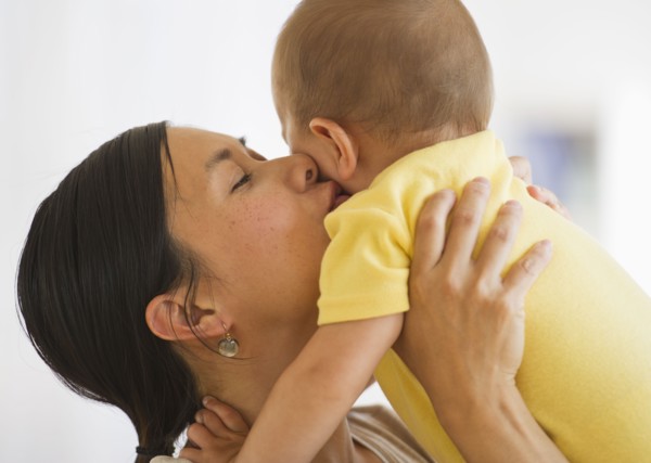 Mother carrying and kissing son (6-11 months). Photo : Daniel Grill