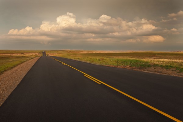 USA, South Dakota, Road in Badlands National Park at sunset.