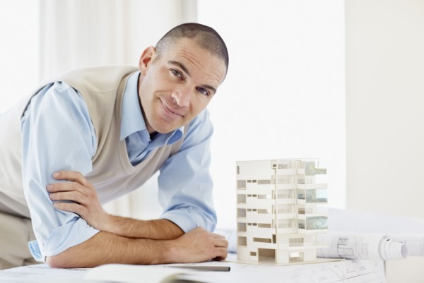 Portrait of architect with apartment model. Photo : Momentimages