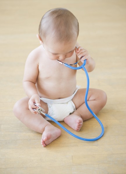 Baby boy (12-17 months) playing with stethoscope. Photo : Daniel Grill