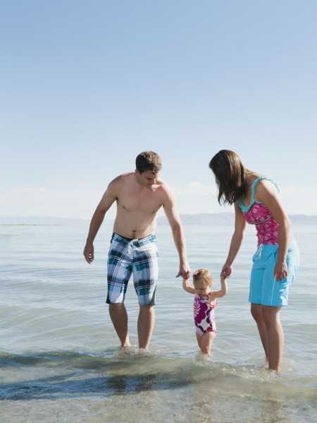 Parents with baby daughter (12-18months) playing on holidays.