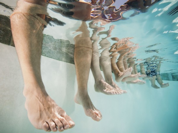 Family with four kids (12-18months, 4-5,6-7,8-9) on swimming pool.