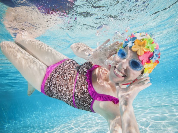 Girl (8-9) swimming underwater.