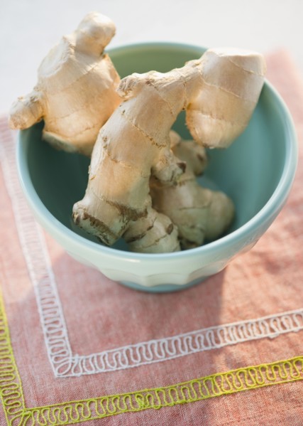 Fresh ginger root in bowl, high angle view. Photo : Jamie Grill