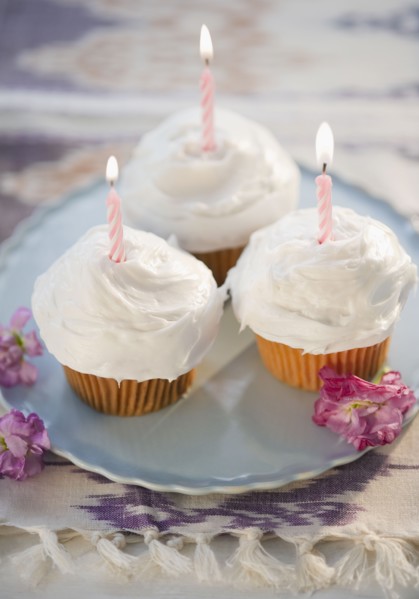Cupcakes with burning birthday candles, high angle view. Photo : Jamie Grill
