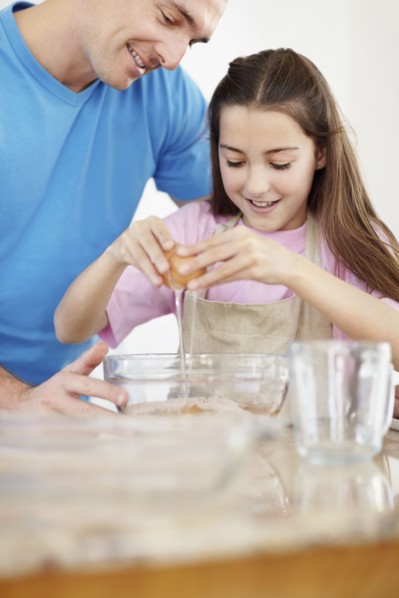 Daughter (10-11) helping father prepare food. Photo : Momentimages