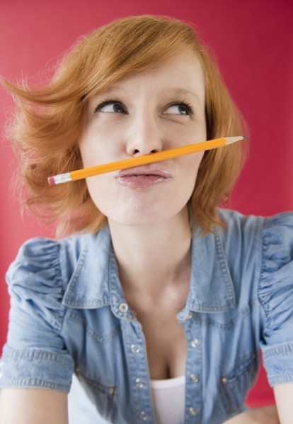 Young woman playing with pencil. Photo : Jamie Grill