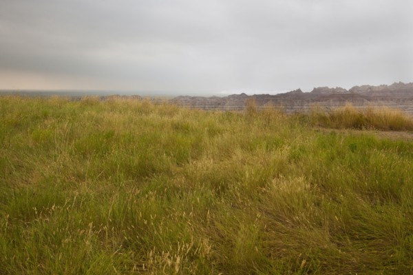USA, South Dakota, Stormy clouds over prairie grass in Badlands National Park.