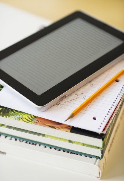 Digital tablet on stack of books.