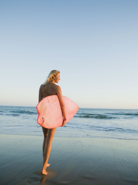 Portrait of woman with surfboard.