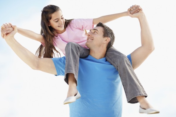Father carrying daughter (10-11) on back. Photo : Momentimages