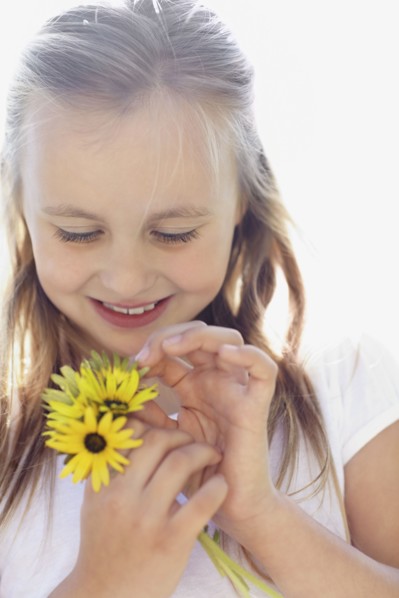 Girl (10-11) with sunflowers. Photo : Momentimages