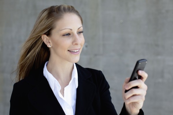 Businesswoman using mobile phone. Photo : Johannes Kroemer