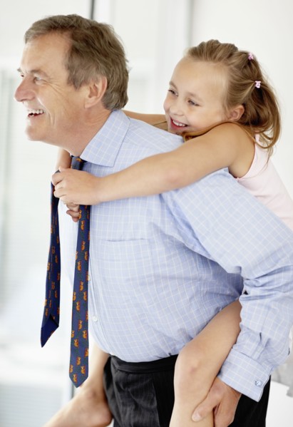 Father carrying girl (10-11) on back. Photo : Momentimages