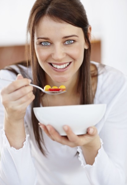 Portrait of mid adult woman eating from bowl. Photo : Momentimages