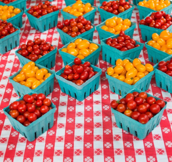 Boxes with cherry tomatoes on table.